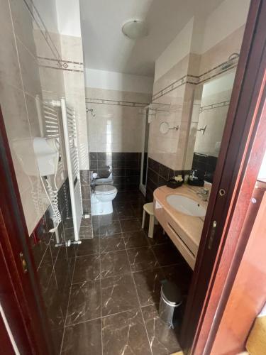 ein Bad mit einem Waschbecken und einem WC in der Unterkunft Panorama Hotel in Muggia