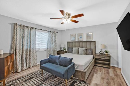 a bedroom with a bed and a ceiling fan and a chair at Modern 3BR Home w Grill, Hot tub, close to Strip in Las Vegas