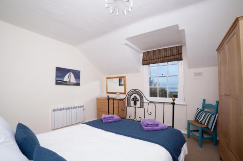 a bedroom with a bed and a window at Fort Victoria Cottages - Sea View Cottage in Yarmouth