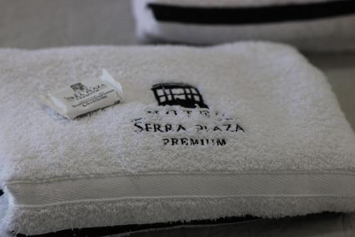 een stapel handdoeken met een foto van een kooi erop bij Serra Plaza Premium in Serrinha