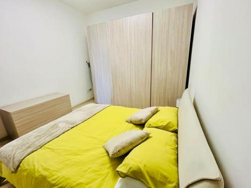 Bett mit gelber Bettwäsche und Kissen in einem Zimmer in der Unterkunft XL Seafront Home in Sliema in Sliema