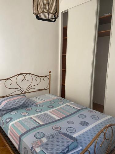 Una cama con edredón en un dormitorio en T2 Marché de Bastia, en Bastia