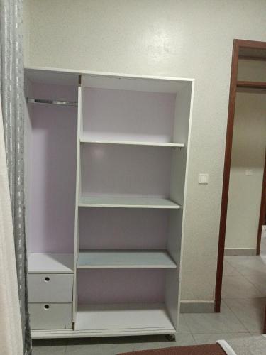 a closet with white shelves in a room at VENUS Villa BOUTIQUE HOTEL KIGALI in Kigali