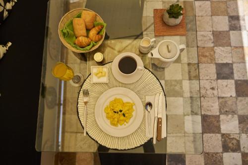 einen Tisch mit einem Teller Essen und einer Tasse Kaffee in der Unterkunft Pucllana BBBoutique in Lima