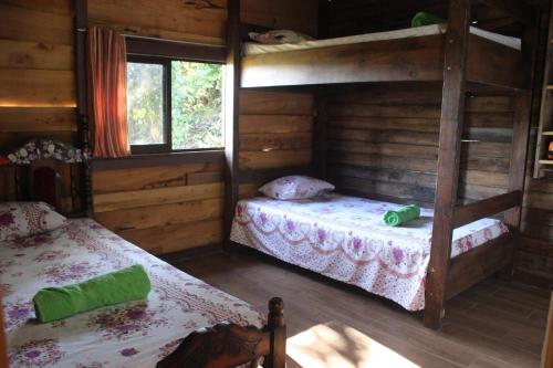 Rancho Los Duendes في توريالبا: غرفة نوم مع سريرين بطابقين في كابينة