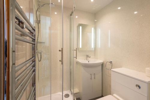 y baño con ducha, lavabo y aseo. en Tregurrian Villas, en Newquay