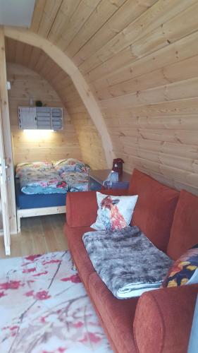 una sala de estar con sofá y una habitación con 2 camas en Tiny House Cuxhaven am See, en Nordholz