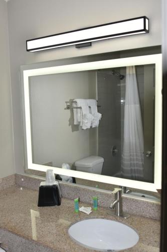 a bathroom mirror with a sink and a shower at Super 8 by Wyndham Biloxi in Biloxi