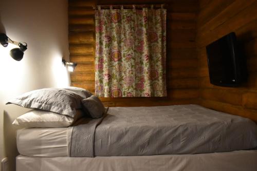 a bedroom with a bed with a curtain and a television at Finca La Vilina - Cabaña Aurora in San Rafael