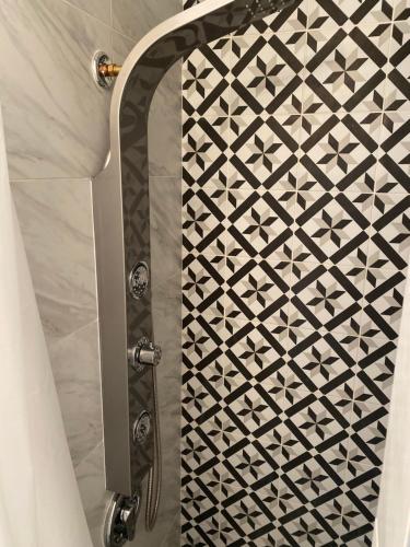 a shower with a black and white patterned shower curtain at Updated Modern House with Cozy Feel in Fort Lauderdale