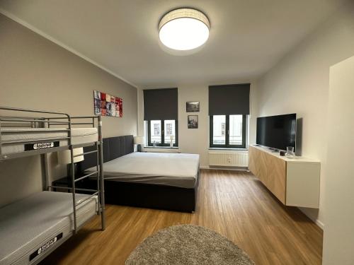 a bedroom with a bunk bed and a flat screen tv at Apartment Arenablick in Leipzig
