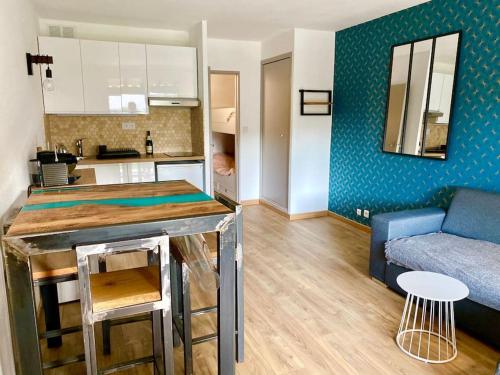 eine Küche und ein Wohnzimmer mit einem Tisch und einem Sofa in der Unterkunft SUPERBE LOGEMENT CLIMATISE à 2 PAS DE LA MER in Saint-Cyr-sur-Mer