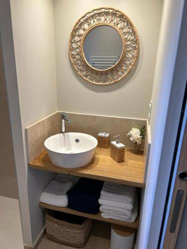 une salle de bain avec un lavabo, un miroir et des serviettes dans l'établissement Escapade paisible au coeur du Luberon, à Grambois