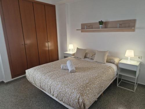 a bedroom with a bed with two tables and a cabinet at Playa Patacona vistas al mar in Valencia