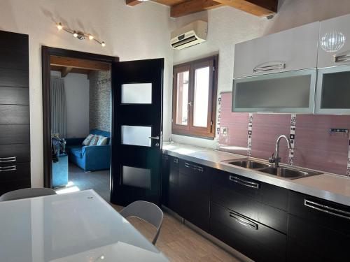 a kitchen with black cabinets and a sink at DOLCE VITA holiday home in Cala Gonone