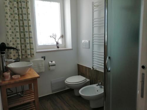 a bathroom with a toilet and a sink and a window at Welcome to Alberobello in Alberobello