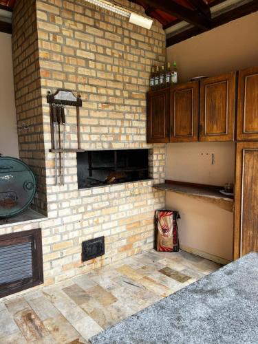 a brick wall with a fireplace in a kitchen at Pousada Casa Chico in Navegantes