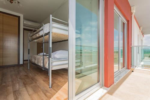 コンソラサオンにあるBest Houses 02 - Brand New, Modern & Cozy - Steps From The Beachのベッドルーム(二段ベッド付)、バルコニーが備わります。