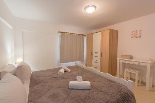 a bedroom with a bed with two towels on it at Sunshine House in Episkopianá