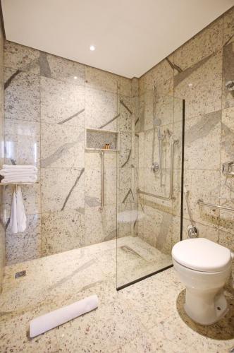 a bathroom with a toilet and a glass shower at DoubleTree by Hilton - Resort - Foz do Iguaçu in Foz do Iguaçu