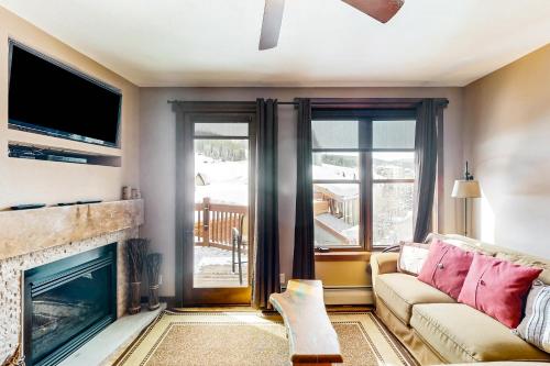 a living room with a couch and a fireplace at Village Hideaway in Copper Mountain