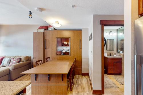 cocina y sala de estar con mesa de madera en Village Hideaway en Copper Mountain