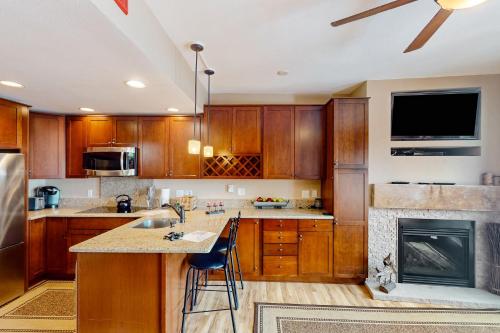 a kitchen with wooden cabinets and a fireplace at Village Hideaway in Copper Mountain