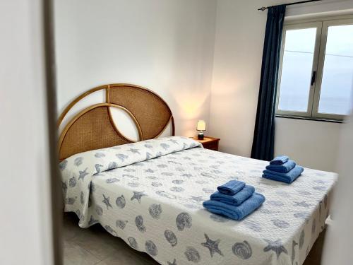 - une chambre avec un lit et des serviettes bleues dans l'établissement Residence Araba Fenice Tropea, à Tropea