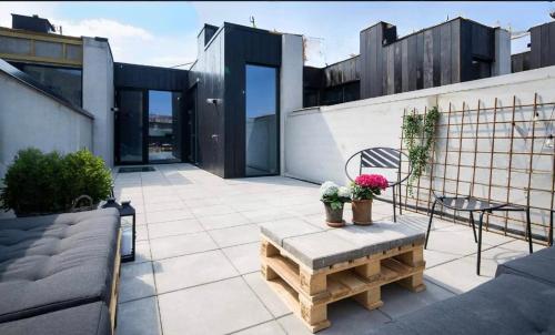 um pátio com um banco e uma mesa num edifício em Large house in New York style with a private rooftop terrace. em Copenhague