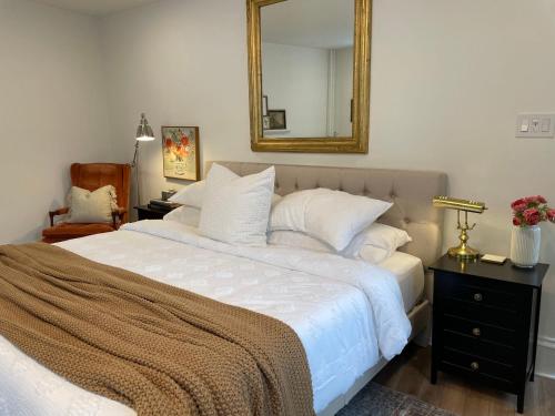 Un dormitorio con una gran cama blanca con espejo. en Charming Hillside Retreat in the Heart of Manayunk, en Filadelfia