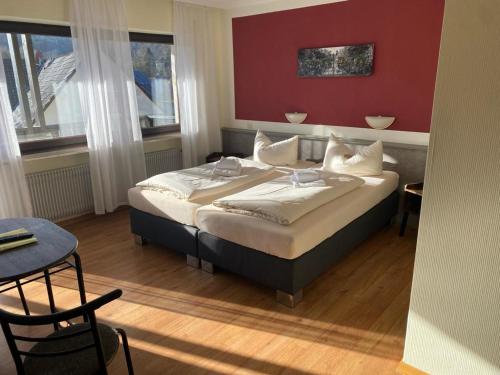 um quarto com uma cama grande e uma parede vermelha em Gasthaus Post em Goldbach