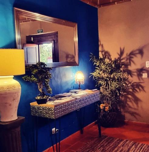 a blue room with a vanity with a mirror and two plants at Monte Santa Catarina in Monsaraz