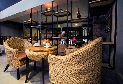 a restaurant with wicker chairs and a wooden table at Vacation Boutique Hotel in Phnom Penh