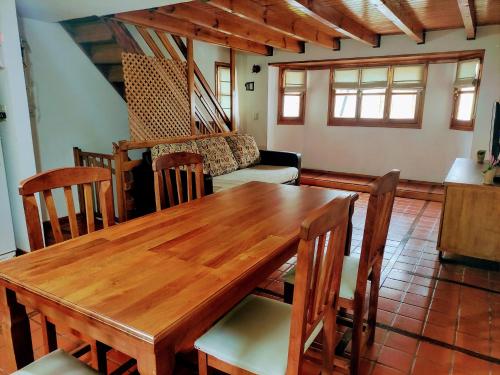 comedor con mesa de madera y sillas en Cabaña Camalen en San Martín de los Andes