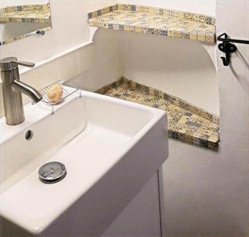 La salle de bains est pourvue d'un lavabo blanc et d'un comptoir. dans l'établissement Château Cottage -Vue sur le Verdon et tranquillité, à Castellane