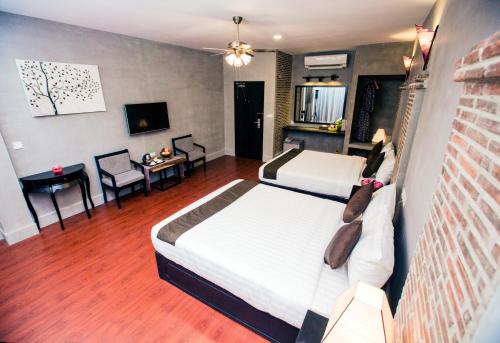 a bedroom with two beds and a living room at Vacation Boutique Hotel in Phnom Penh