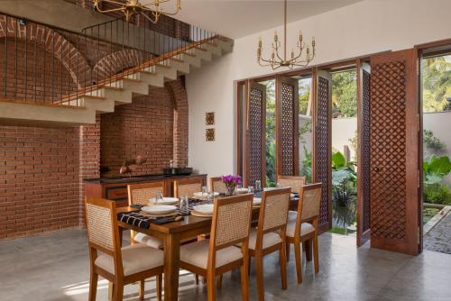 a dining room with a wooden table and chairs at Yahva Bentota in Bentota