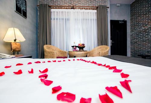 a bed with red rose petals on it at Vacation Boutique Hotel in Phnom Penh