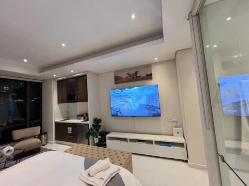 una camera da letto con un grande televisore sul muro di NEW Luxury Hotel Suite Sandton City a Johannesburg
