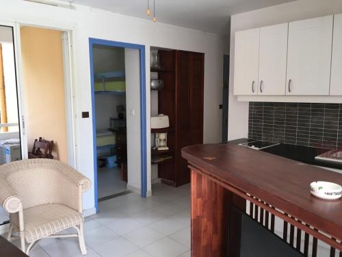 a kitchen with white cabinets and a counter top at Appt 2chb avec piscine in Sainte-Anne