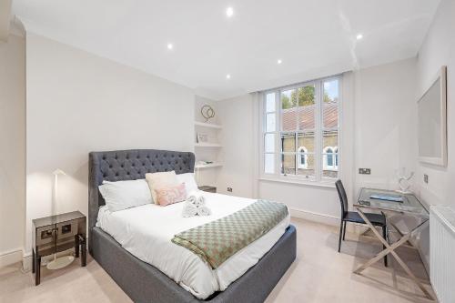 a bedroom with a bed and a desk and a window at Casa Italia near Kensington High Street - Wifi & Washing Machine in London