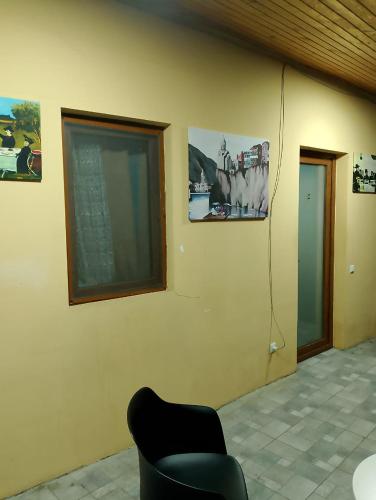 a room with a chair and pictures on the wall at Two Lions Hotel in Tbilisi City