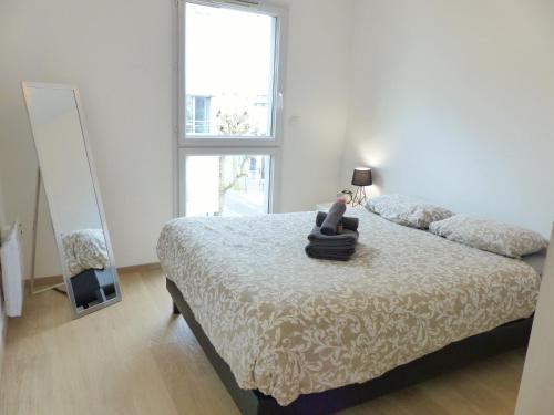 une chambre avec un lit avec un ours en peluche dessus dans l'établissement T2 République Parking inclus, à Nantes