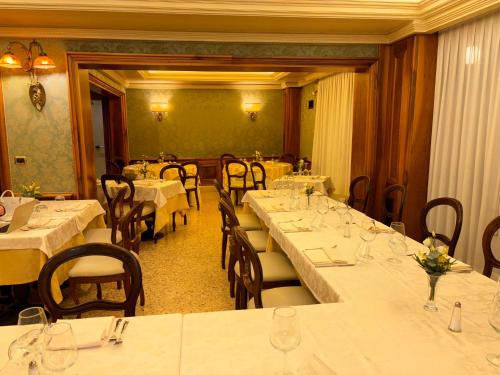 una sala da pranzo con tavoli e sedie con tovaglie bianche di Hotel Ristorante Ca' Nova a Venezia