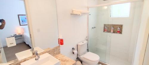 a bathroom with a toilet and a sink and a mirror at Parador Búzios Boutique Hotel in Búzios