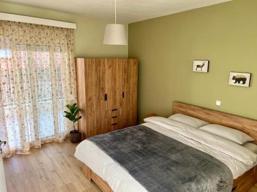Edessa Woodland Retreat في إيديسا: غرفة نوم بسرير كبير ونافذة كبيرة