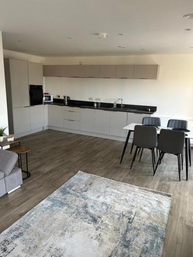 a living room with a table and chairs and a kitchen at Two bedroom, Sleeps 6 Centre of Portrush Main Street Coastal Links apartment 11 in Portrush