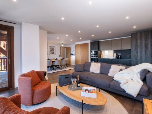 un salon avec un canapé, des chaises et une table dans l'établissement Appartement raffiné à Courchevel Moriond pour 8 personnes, proche pistes et commerces - FR-1-563-148, à Courchevel