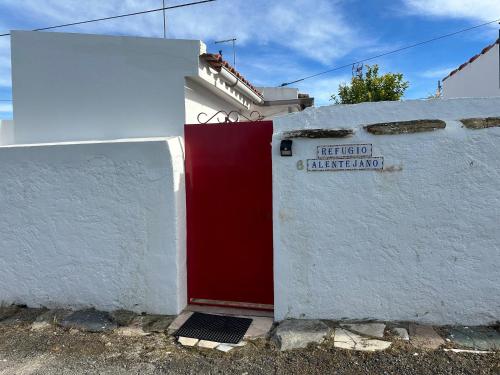 a red and white building with a red door at Refúgio Alentejano in Estremoz
