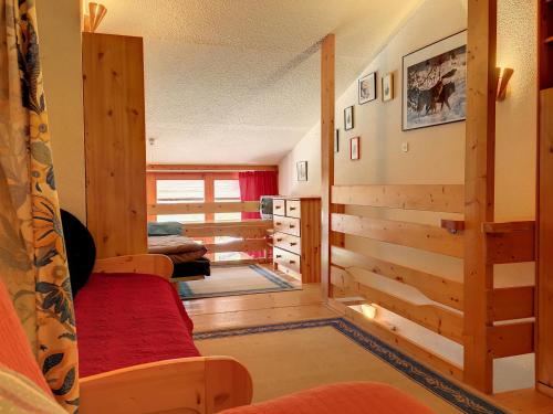 a living room with wooden walls and a red couch at Studio Les Arcs 1800, 2 pièces, 5 personnes - FR-1-346-426 in Arc 1800